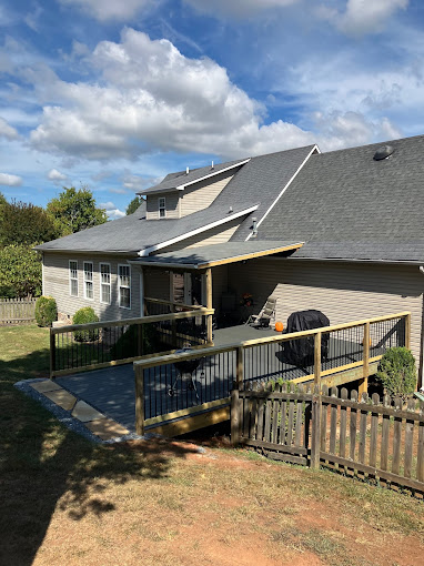 Suburban house with wooden deck and fence on a sunny day